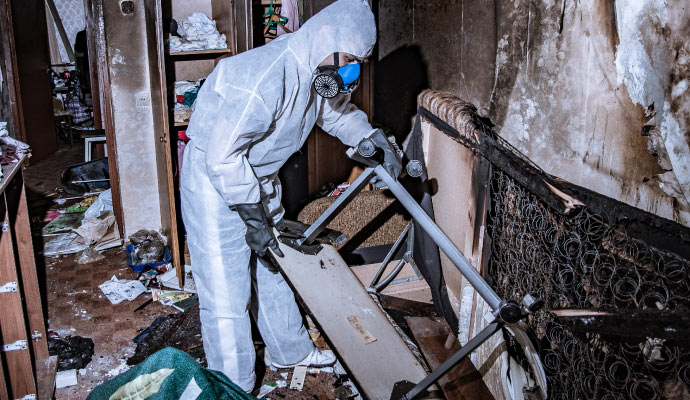 A person cleaning fire damage in a room