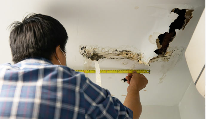 An experts restoring a water-damaged ceiling.